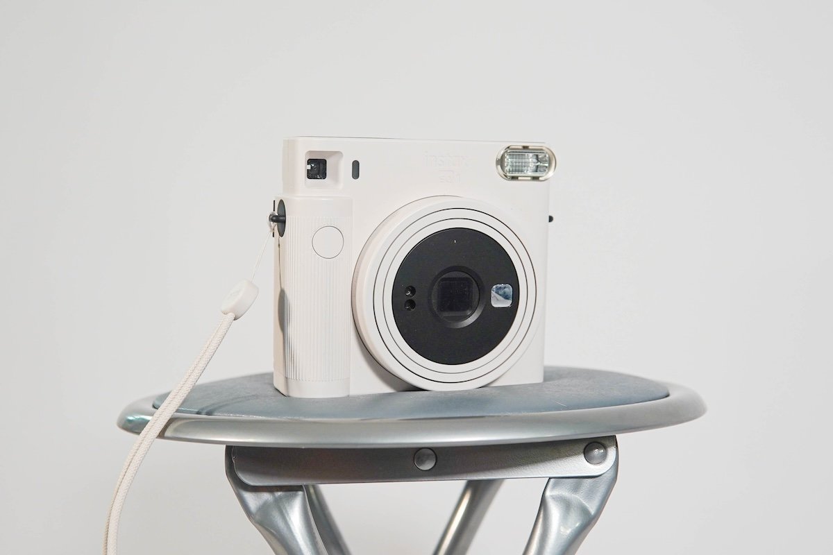 A Fujifilm SQ1 Intax instant camera on a stool