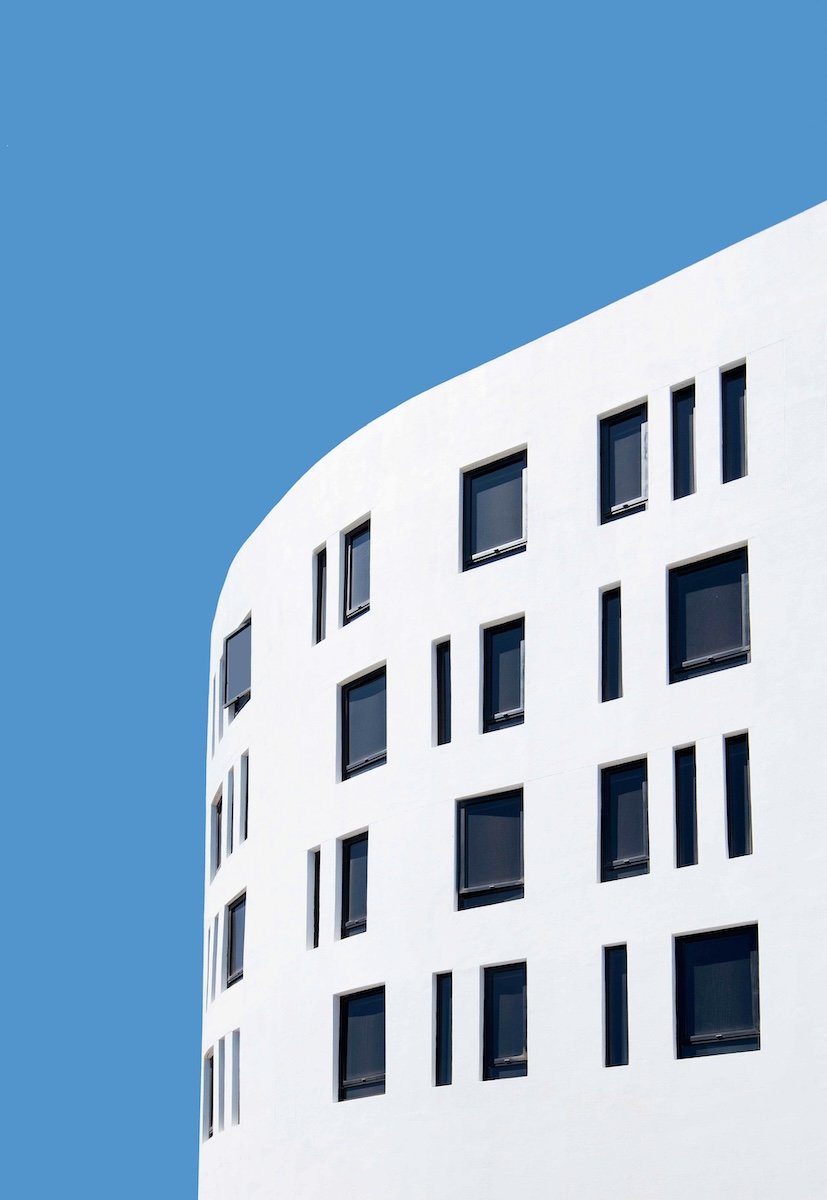 A modern white building against a blue sky shot in a minimalist way