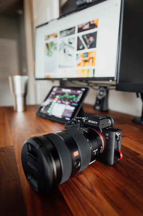 Sony A7R em uma mesa em frente a uma tela de computador