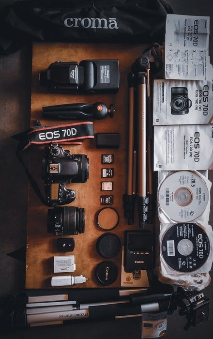 a flay lay of camera and camera accessories laid out on a table
