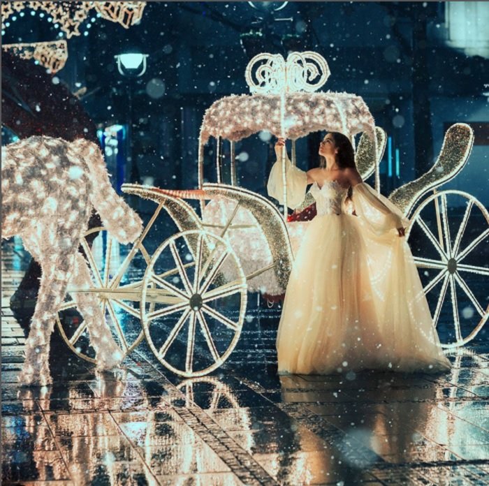 Mulher de vestido de baile com um cavalo espumante e carruagem como uma ideia para fotografia de conto de fadas