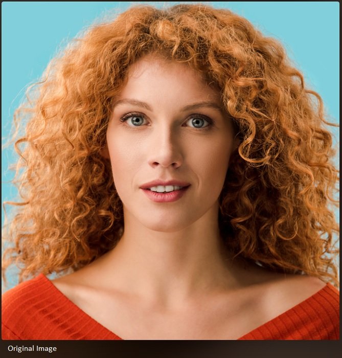 Close portrait of woman with red curly hair and blue eyes
