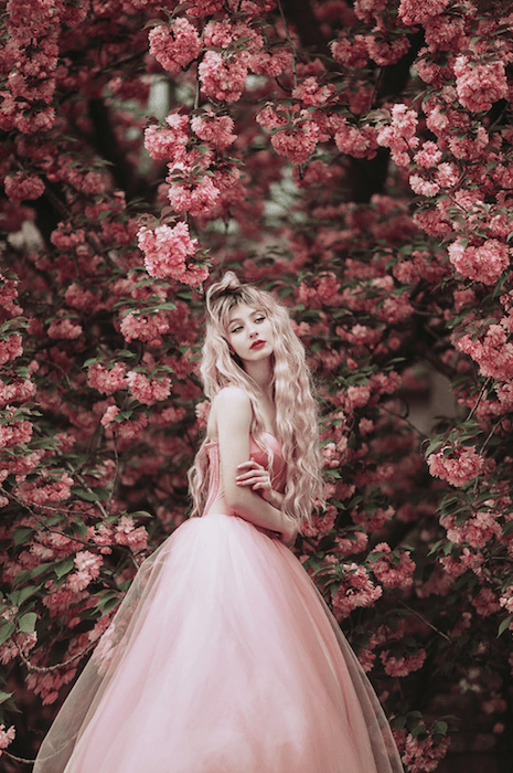flower photography photoshoot of a woman in a pink dress posing with pink flowers