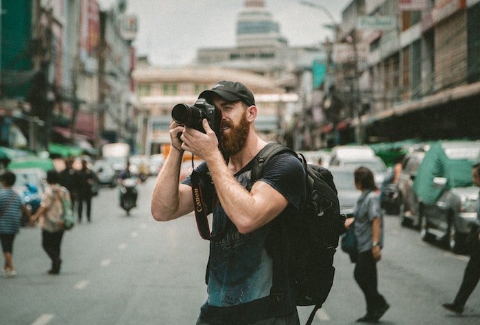 旅行摄影师在街道中间拍照