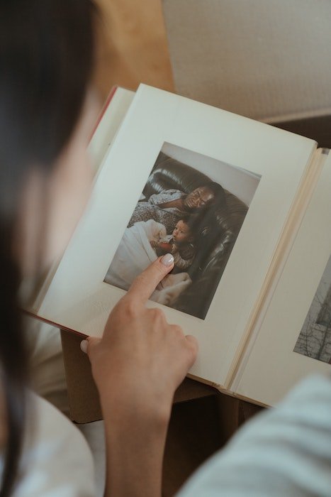 Mulher olhando para um álbum de fotos com uma foto impressa 4x6