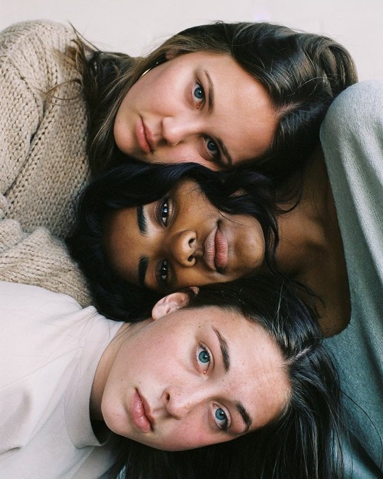 Three young women with their heads stacked together for a best friend photoshoot