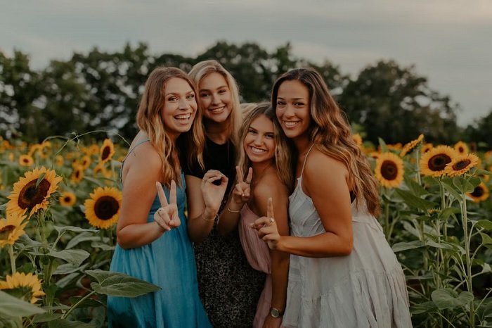 Four female friends in a sunflower field