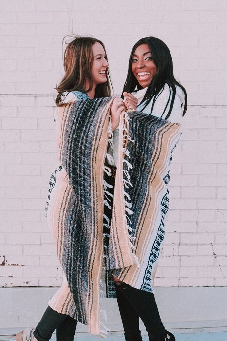 Two women wrapped in a blanket for a best friend photoshoot