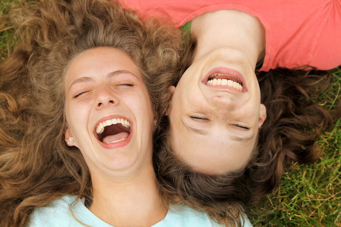 Two female friends at lakeside posing for smartphone selfie stock photo