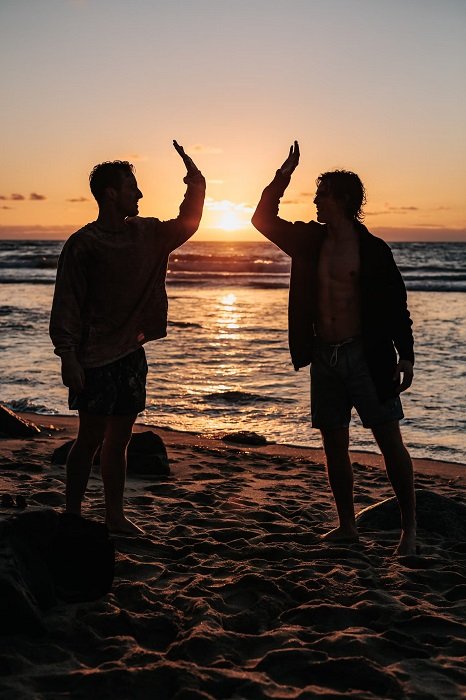 Two men giving a high five on a beach
