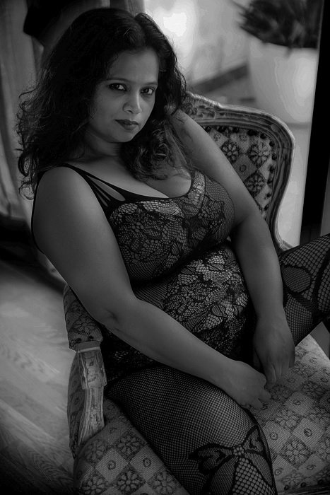 Woman in lingerie sitting in chair posing for boudoir photography