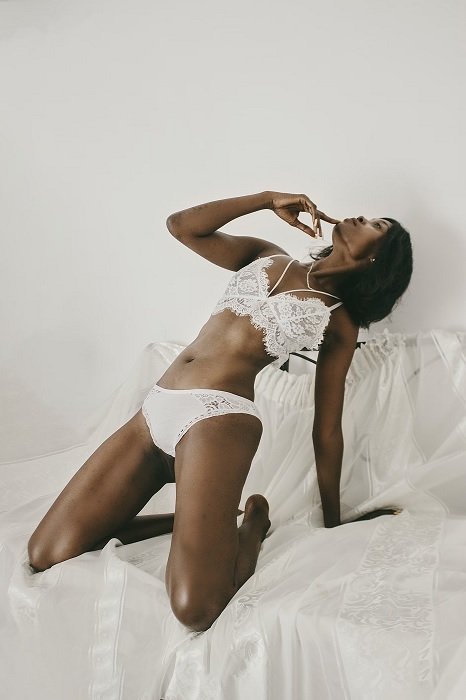 Woman in white lingerie leaning back on knees as an idea for boudoir poses