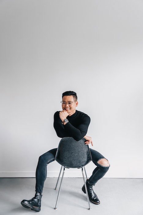 Man sitting on a backward chair as an example of male poses