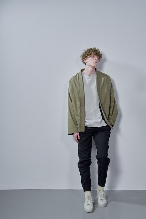 A male model leaning on the wall as an idea for male fashion poses