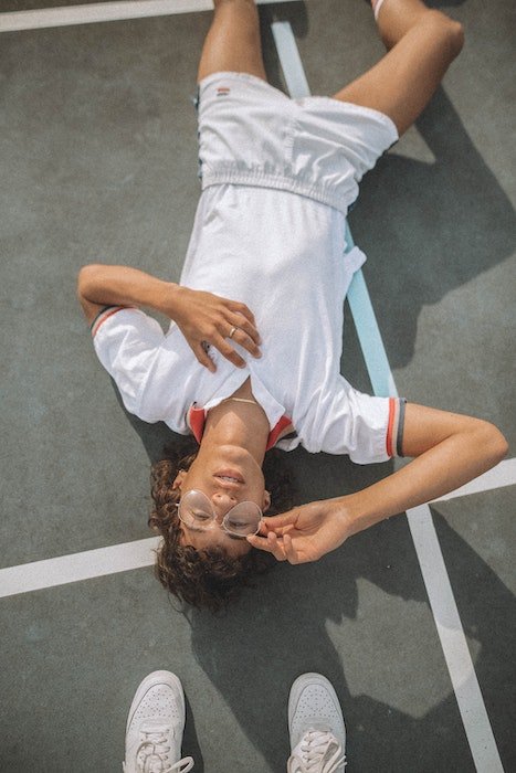 Model lying down on a tennis court