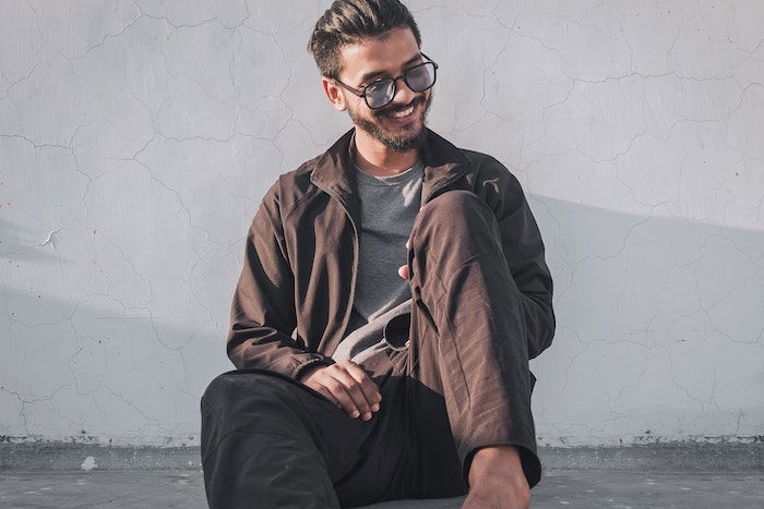 Male posing idea of a man leaning against wall and laughing