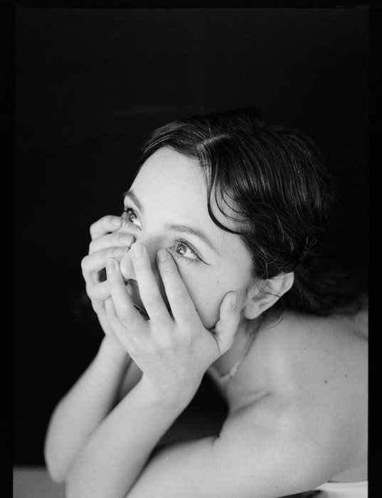 Model pose idea of a black and white image of a woman with hands on her face