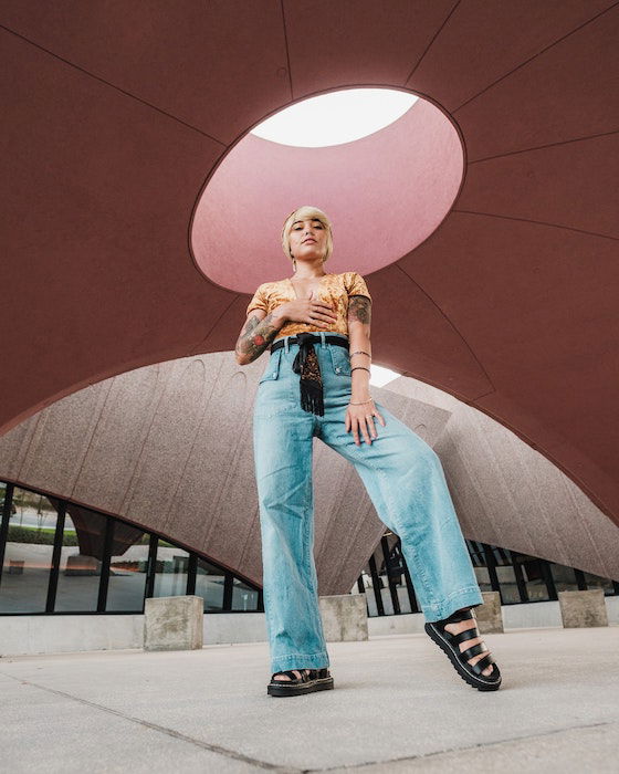 A woman in a crop top and jeans poses for a picture photo – Free Denim  Image on Unsplash