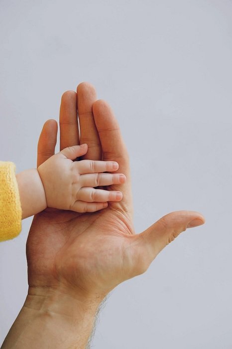 Baby's hand in adults hand as newborn photo idea