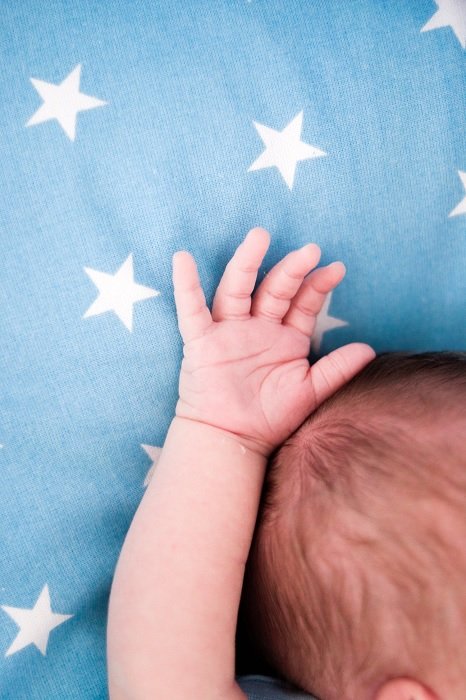 Baby's hand and arm on blue blanket as an idea for newborn photos