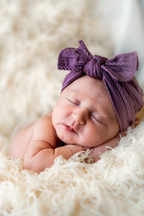 Baby with bow on its head as an idea for a newborn photoshoot