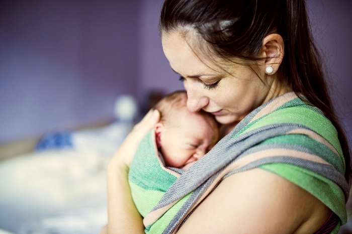 Mother holding baby to her chest as newborn photo idea
