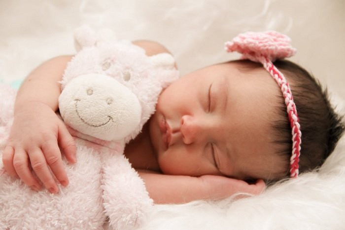 Baby girl with cuddly toy as newborn photo idea