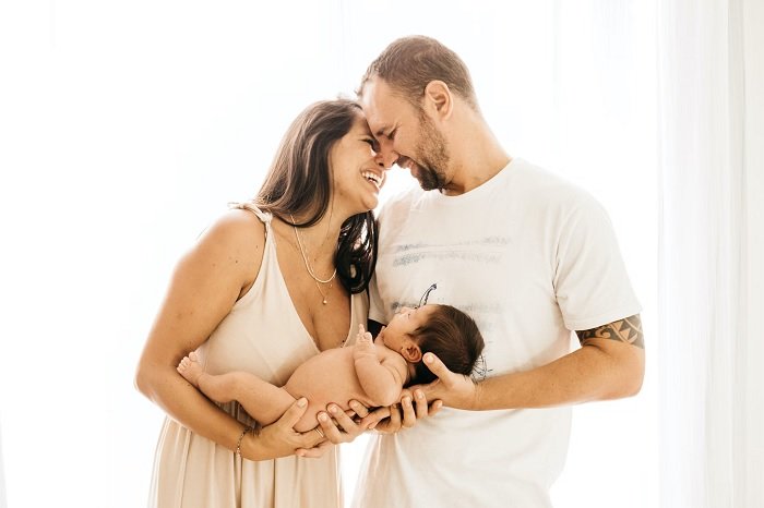 Mother and father holding their baby together as newborn photo idea