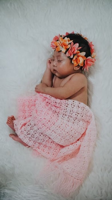 Baby girl with floral headdress as newborn photo idea