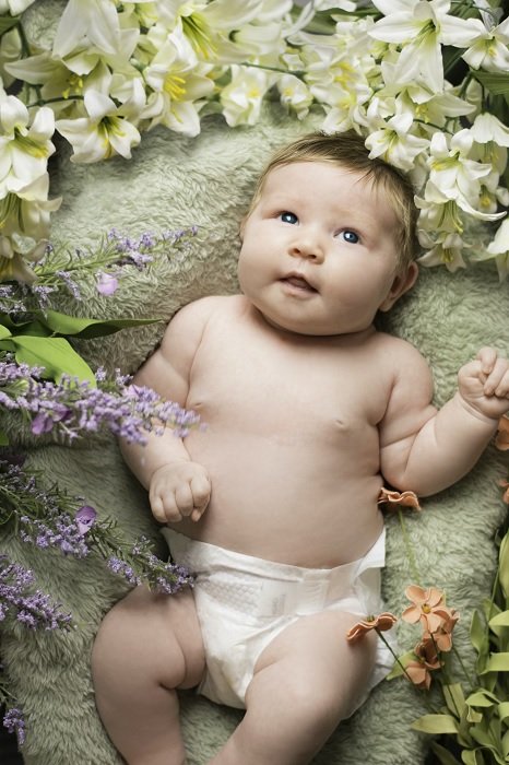 Baby surrounded by flowers as an example of a newborn photoshoot