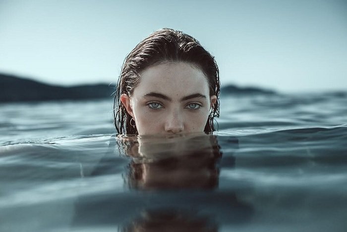 portrait of a model with head popping out of the sea