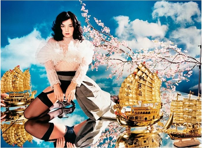Bjork kneeling on a mirror with golden ships