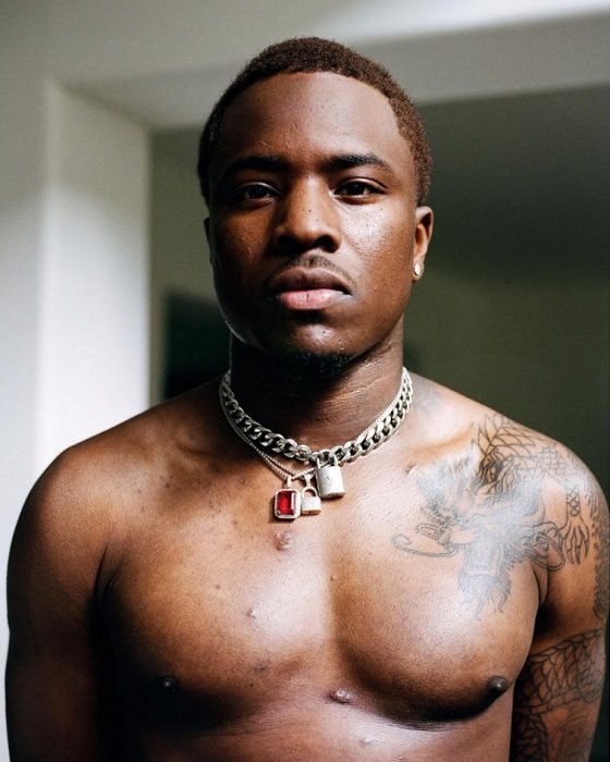 a shirtless man wearing three silver chains