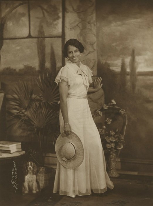 black and white print of lady holding a straw hat