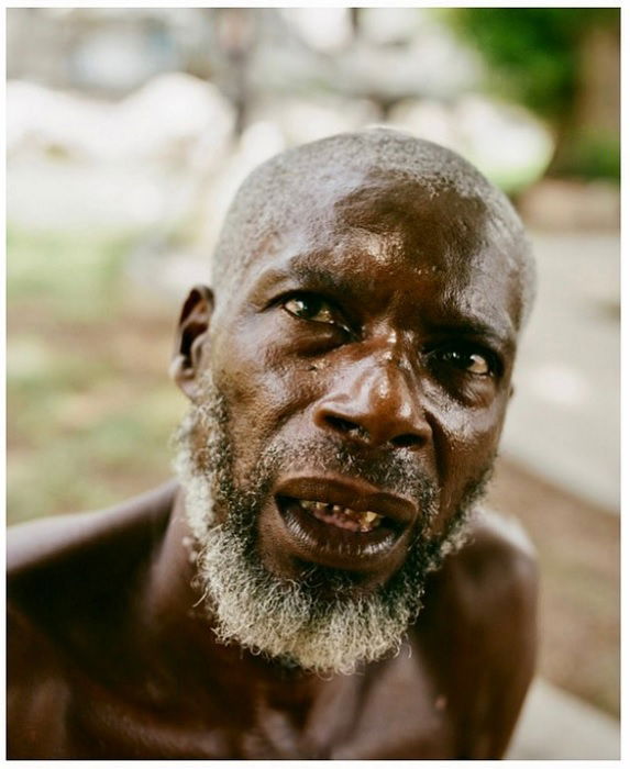 Close up of a shirtless man under a tree