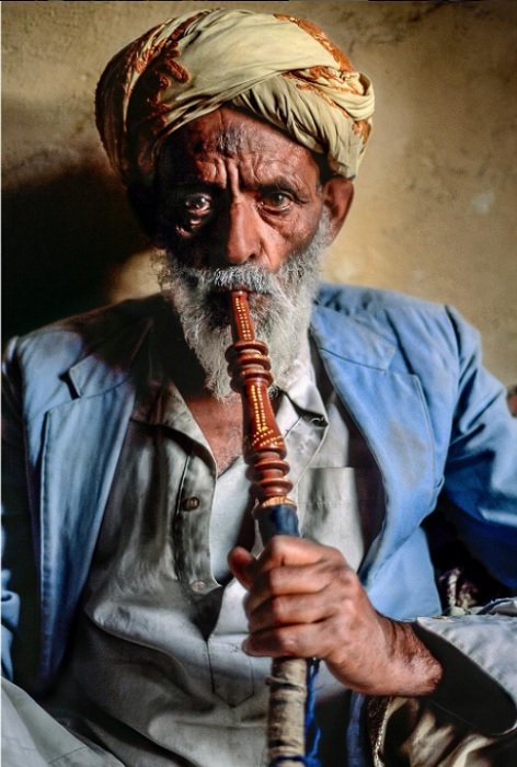 portrait of a man from Yemen smoking shisha pipe