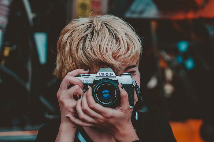 Woman taking a picture with an analog camera