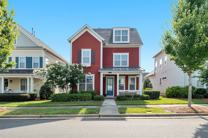 an exterior photo of the front of a house in front of a big blue sky for real estate photography