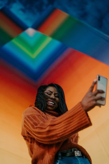 Girl with a colorful background and natural light taking a selfie