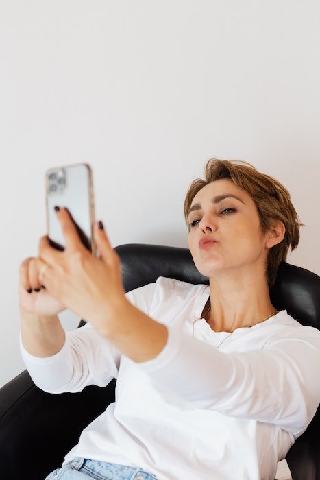 Woman in a selfie pose while extending jaw for no double chin