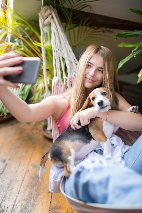 Woman taking a selfie with her dog in natural light