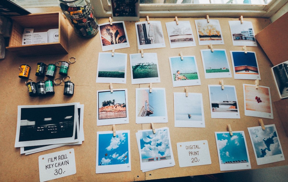 Rolls of film, prints, and polaroid pictures laid out on a table