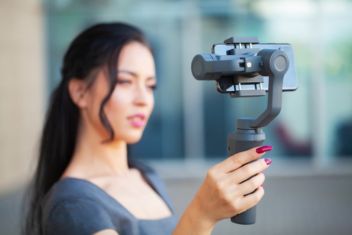 Woman holding a gimbal taking a selfie