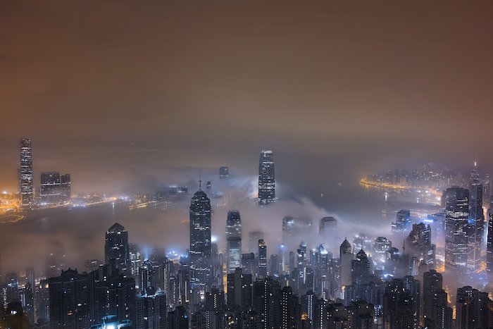 A city at night lit up with lights amongst fog