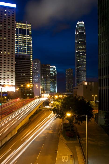 foto de larga exposición de rascacielos por la noche con senderos de luz del tráfico de la calle