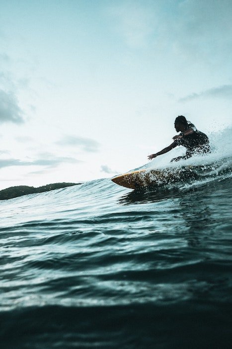 A surfer riding a wave in the morning light as an example for surf photography