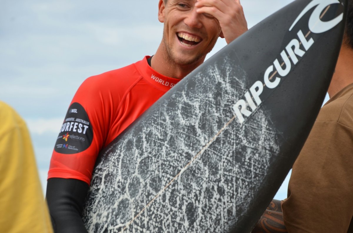 Candid portrait of a surfer with his surfboard as an example of surf photography