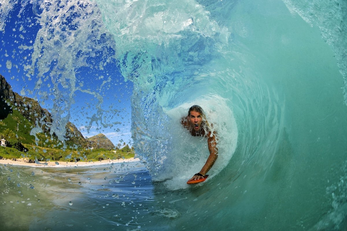 A surfer inside a barrel wave as it is about to crash to shore as an example of surf photography