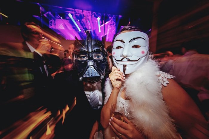 Two people wearing masks at a party