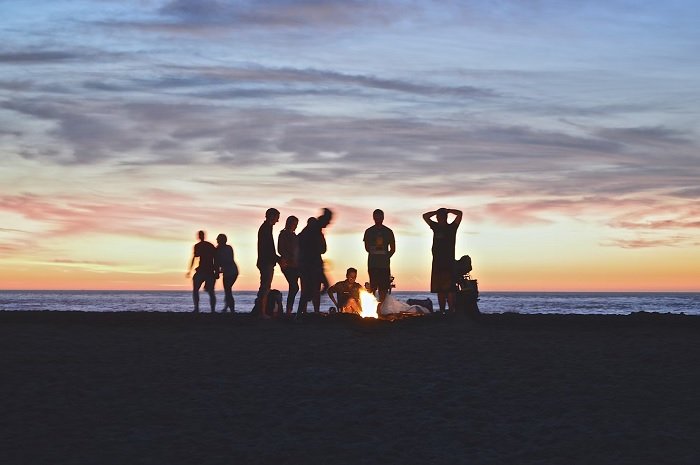 A group of friends on the beach at sunset
